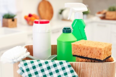 Container with different cleaning supplies in kitchen, closeup