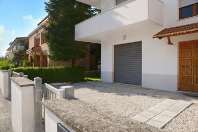 Modern apartment building with yard on sunny day