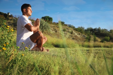 Photo of Man meditating outdoors, space for text. Nature healing power