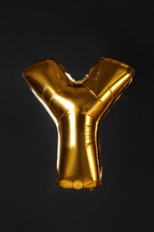 Golden letter Y balloon on black background