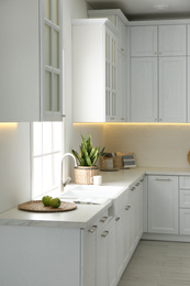 Photo of New ceramic sink and modern tap in stylish kitchen interior