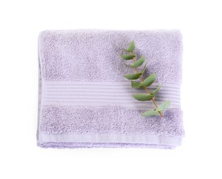 Photo of Folded violet terry towel and eucalyptus branch isolated on white, top view