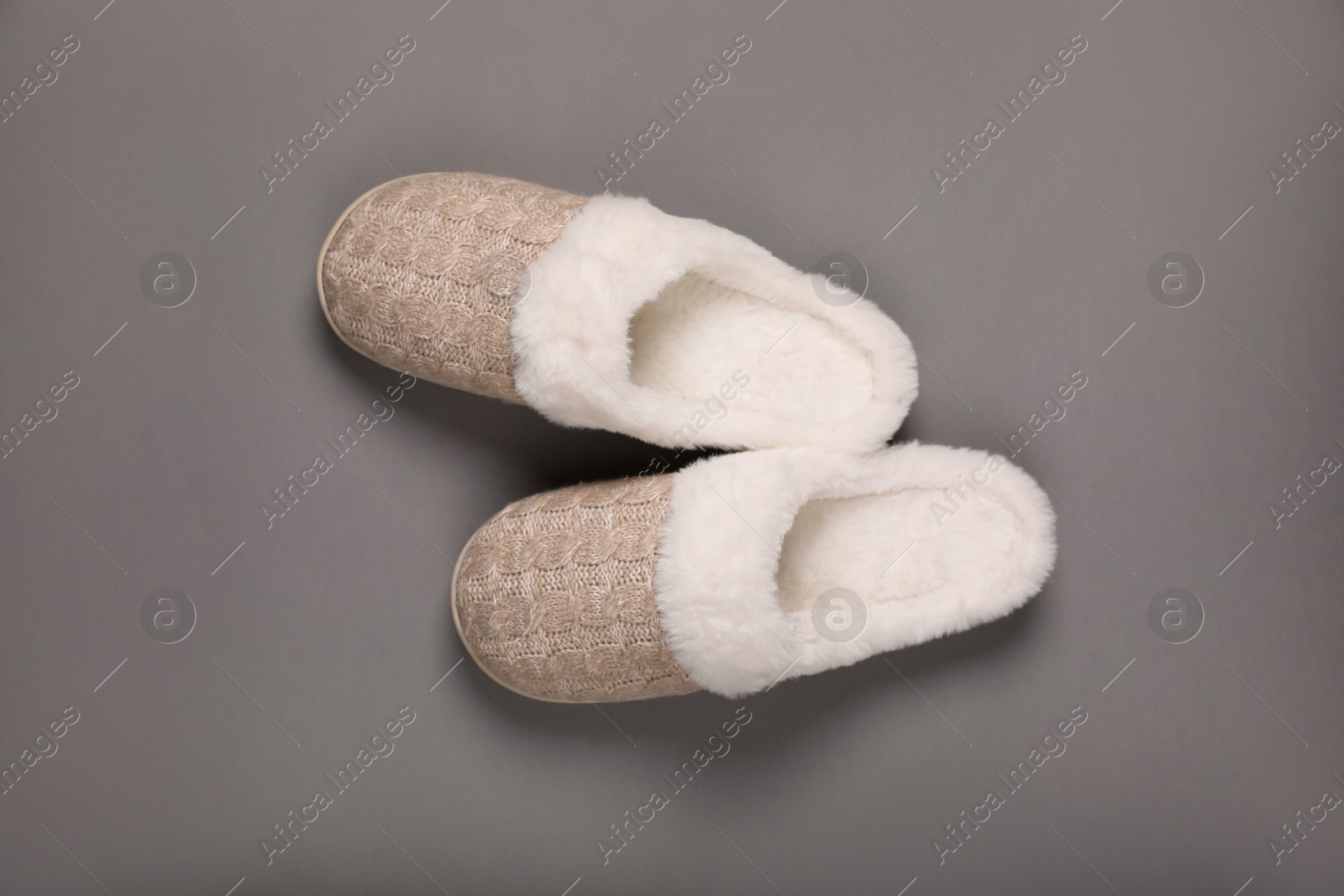 Photo of Pair of beautiful soft slippers on grey background, top view