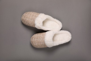 Pair of beautiful soft slippers on grey background, top view