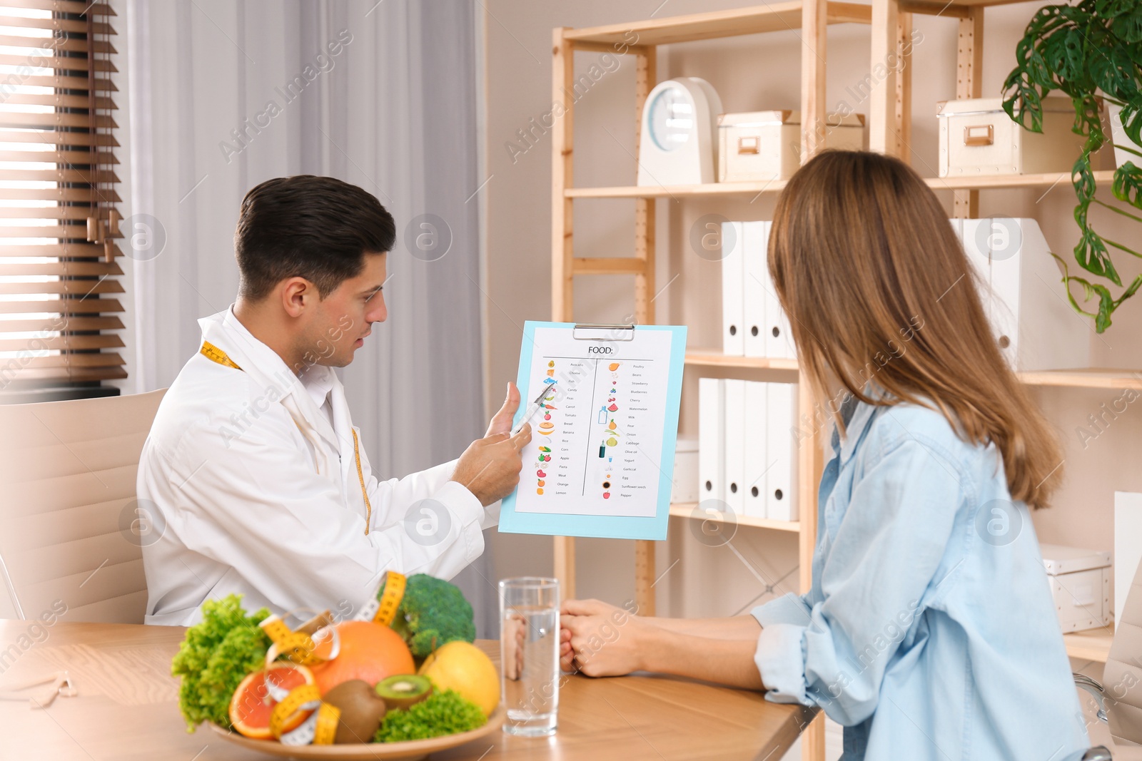 Photo of Nutritionist consulting patient at table in clinic