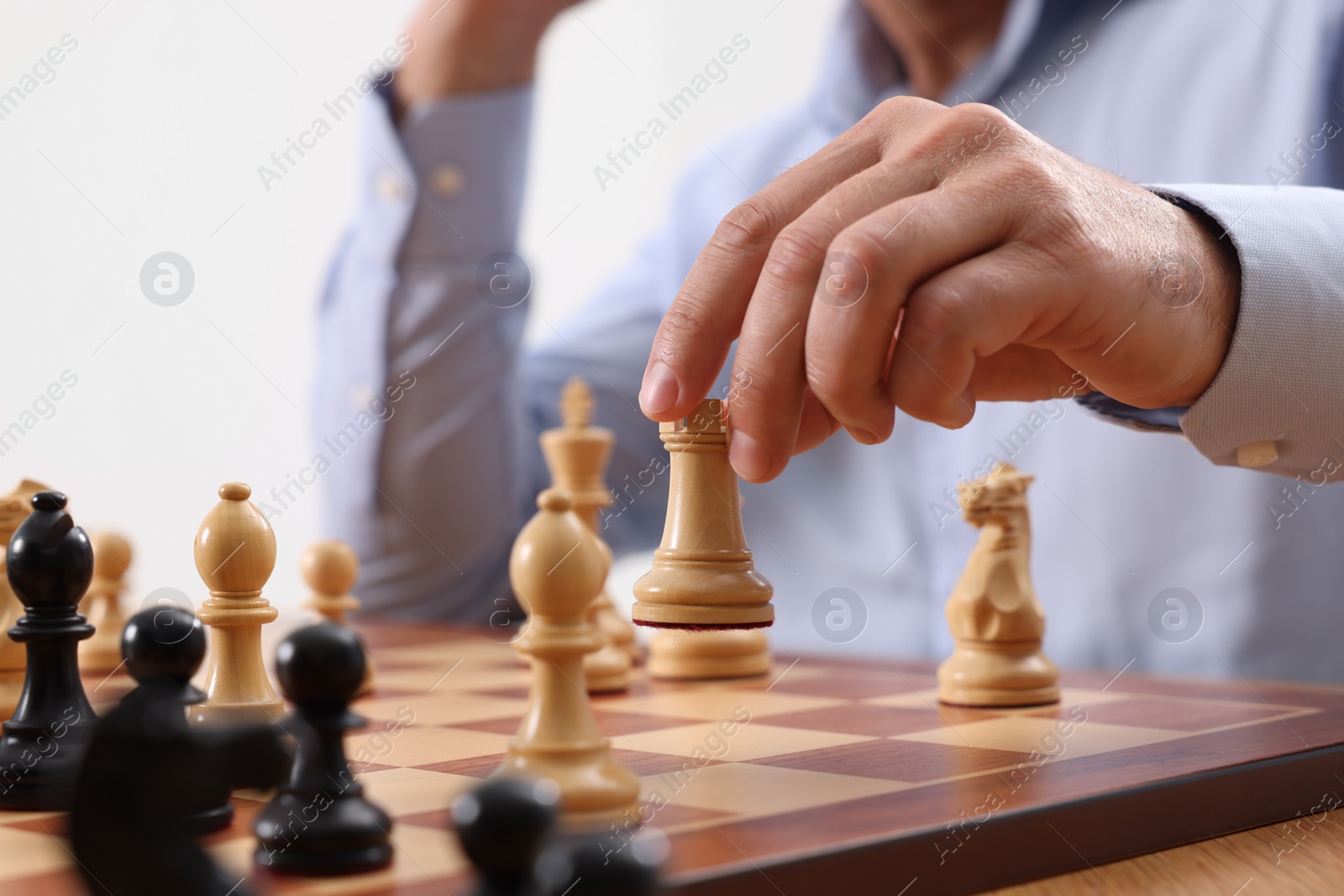 Photo of Man playing chess during tournament at chessboard, closeup