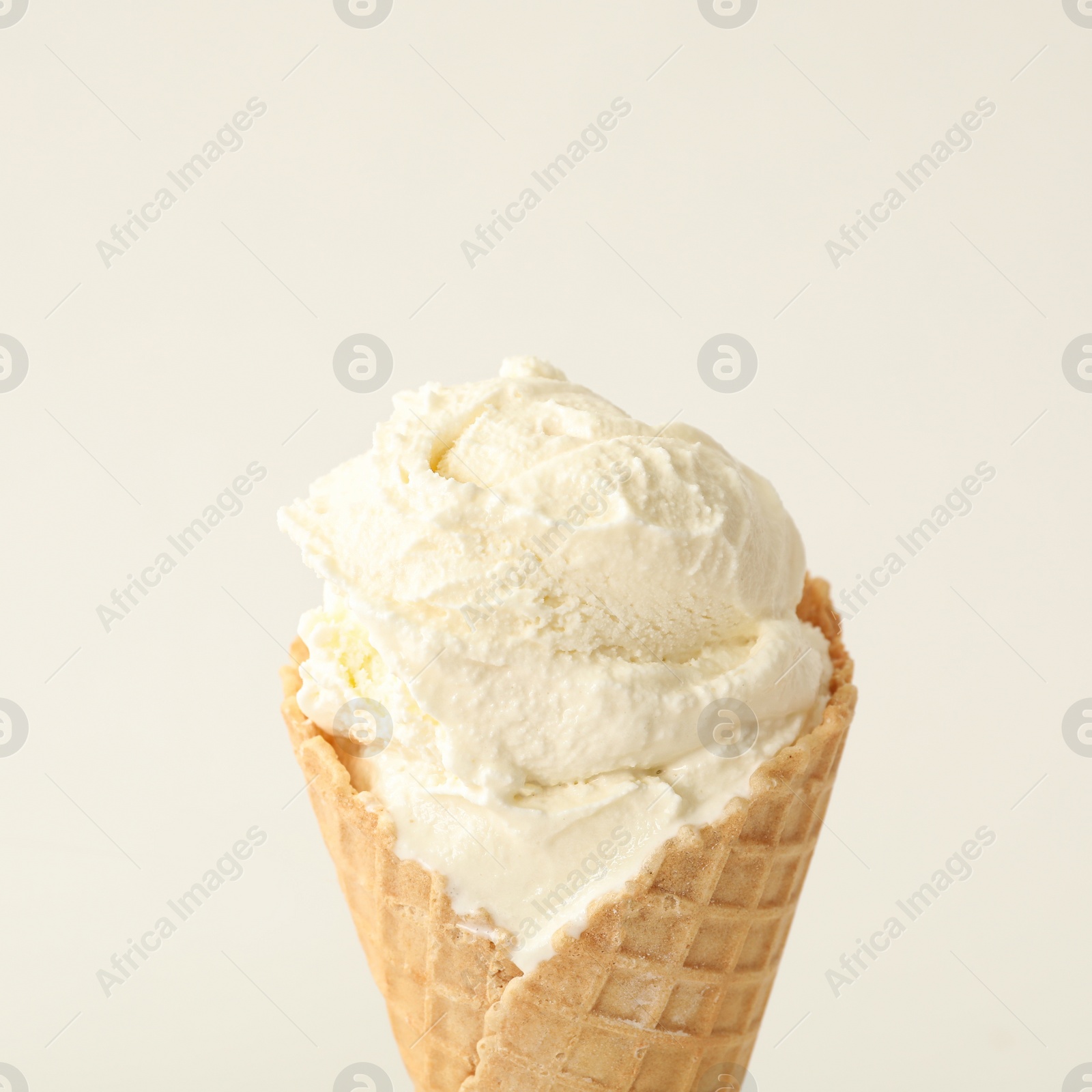 Photo of Delicious ice cream in waffle cone on white background, closeup