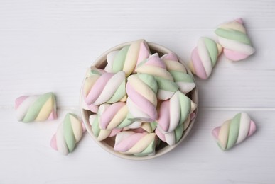 Photo of Bowl with colorful marshmallows on white wooden table, flat lay