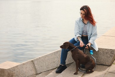 Woman with her cute German Shorthaired Pointer dog outdoors, space for text