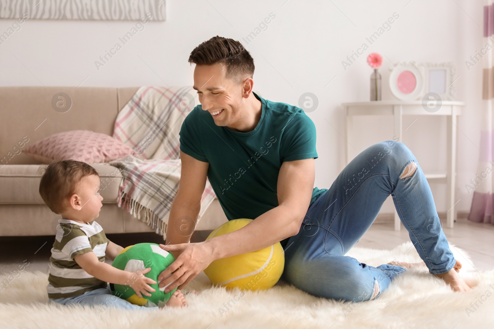 Photo of Young father with his cute little son at home