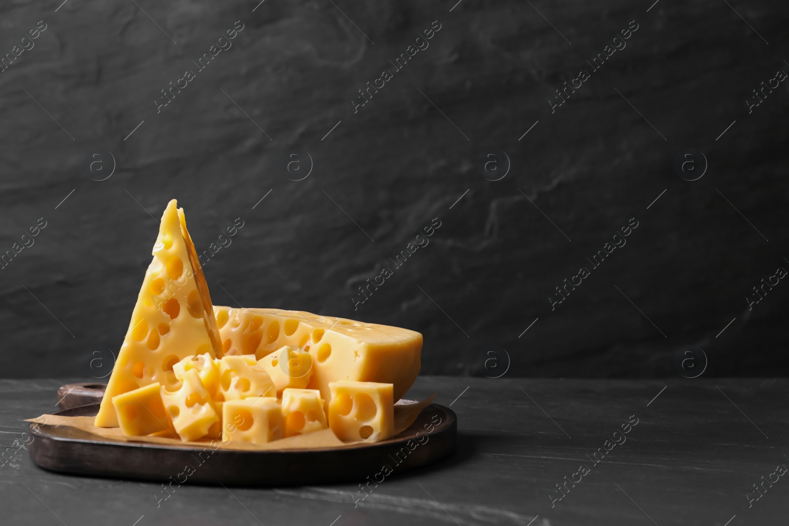 Photo of Tasty fresh cheese on dark grey table, space for text