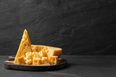Photo of Tasty fresh cheese on dark grey table, space for text