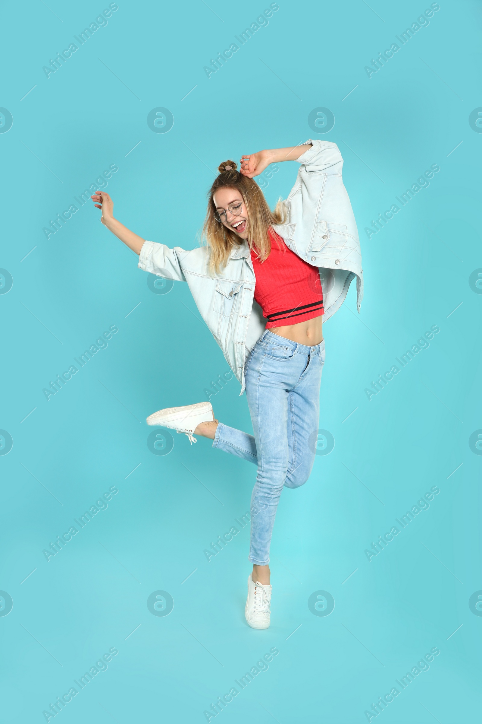 Photo of Full length portrait of emotional woman jumping on color background