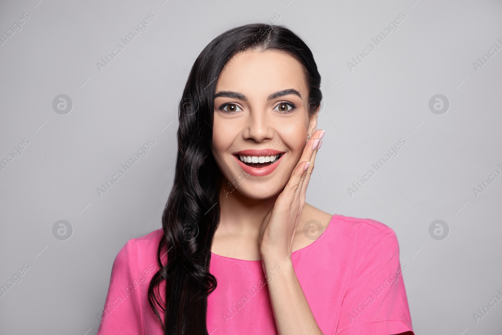 Photo of Portrait of surprised woman on grey background
