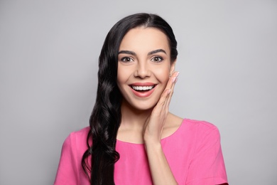 Portrait of surprised woman on grey background