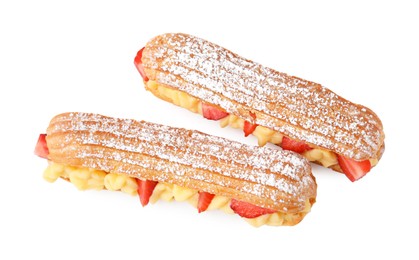 Photo of Delicious eclairs filled with cream and strawberries isolated on white, top view