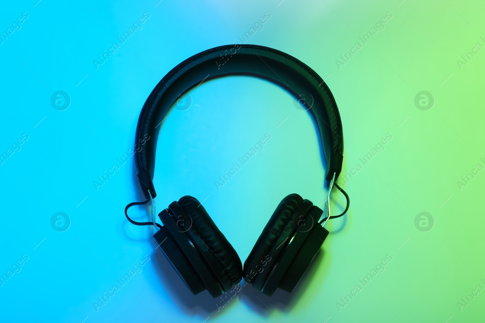 Photo of Stylish headphones on color background, top view