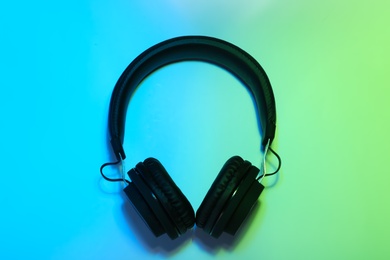 Photo of Stylish headphones on color background, top view