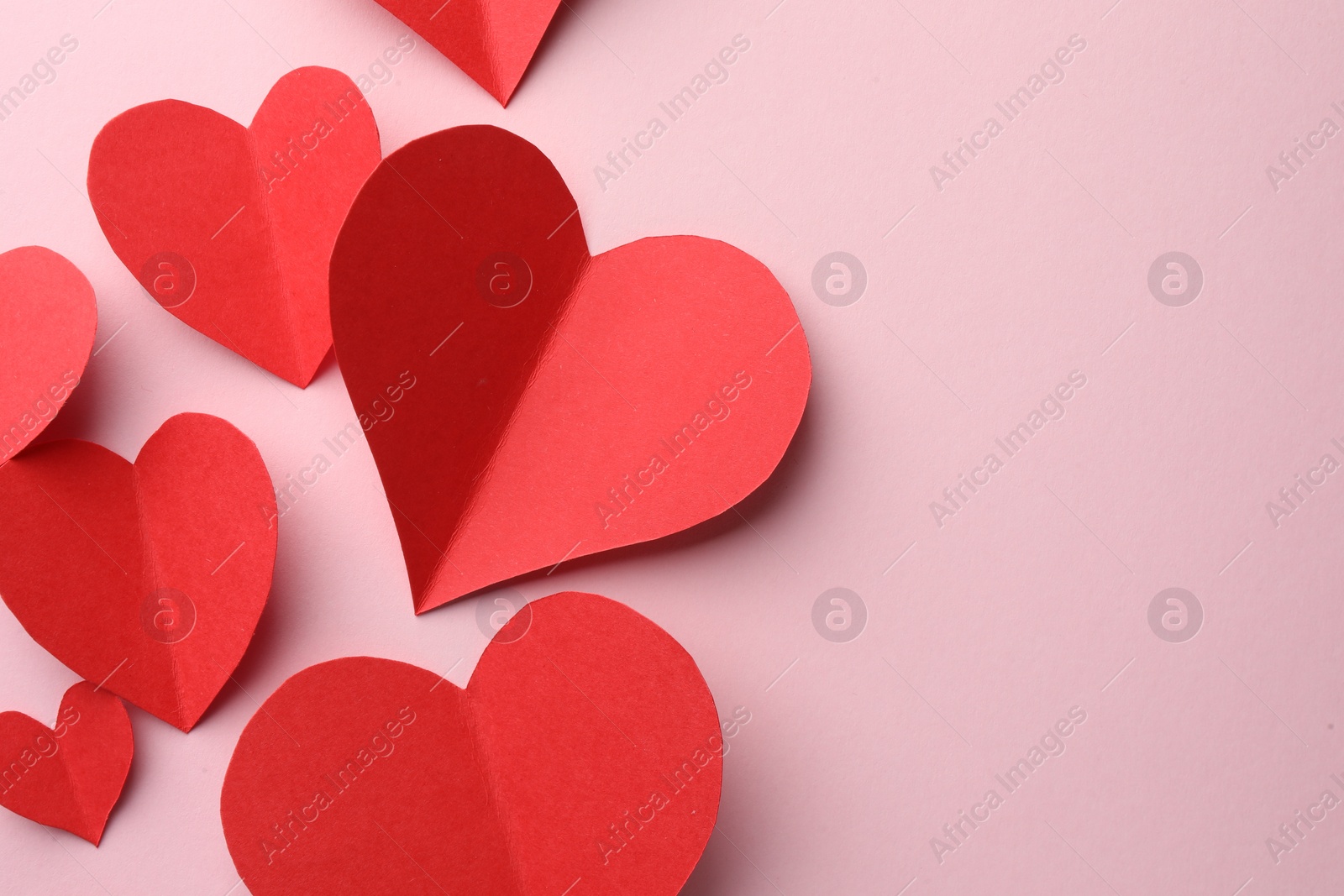 Photo of Paper hearts on pink background, flat lay. Space for text