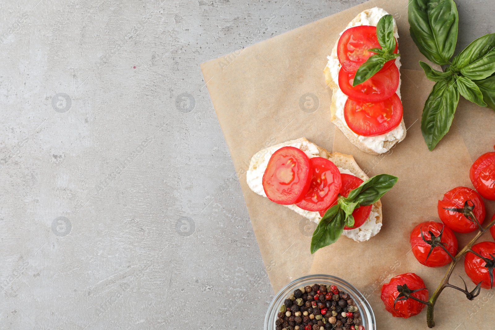 Photo of Tasty fresh tomato bruschettas on grey table, flat lay. Space for text