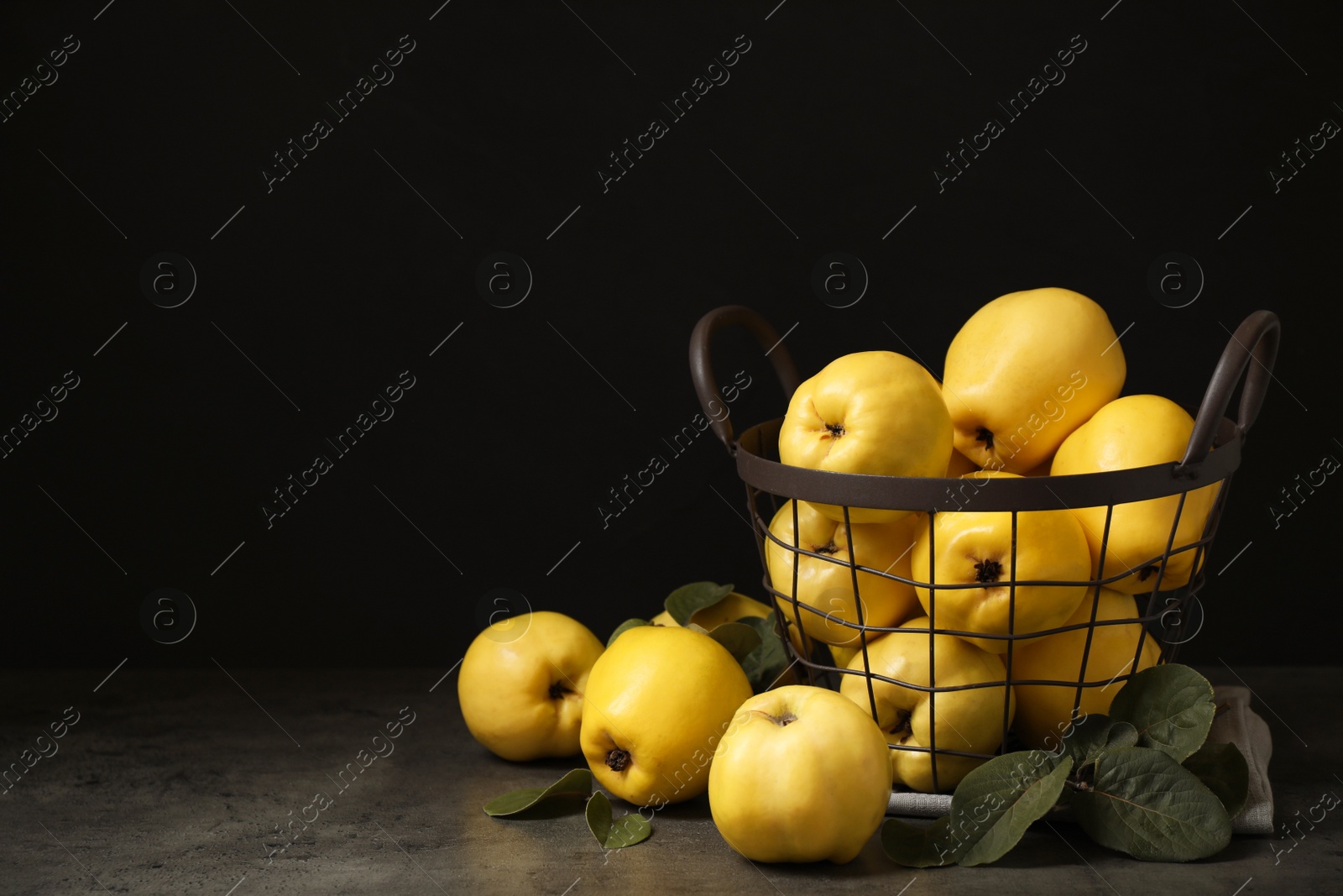 Photo of Fresh ripe organic quinces with leaves on grey table