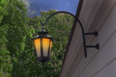 Image of Beautiful old fashioned street lamp lighting on wall of building