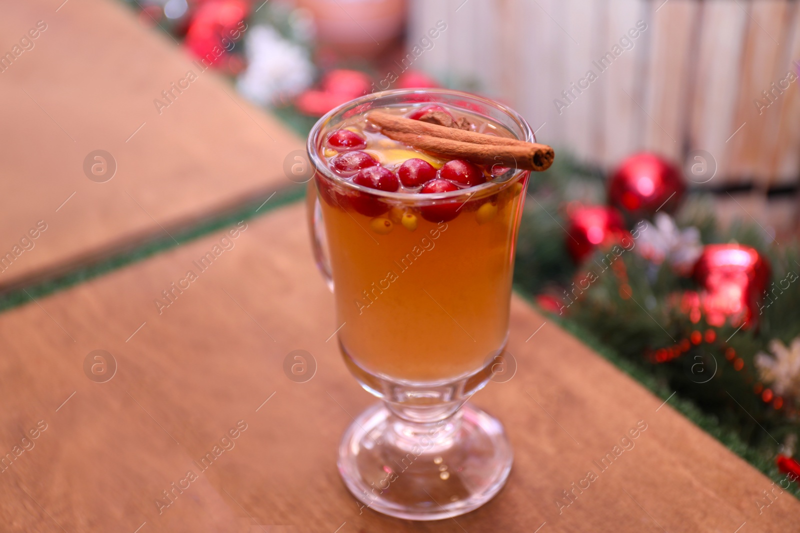 Photo of Tasty aromatic mulled wine on wooden table