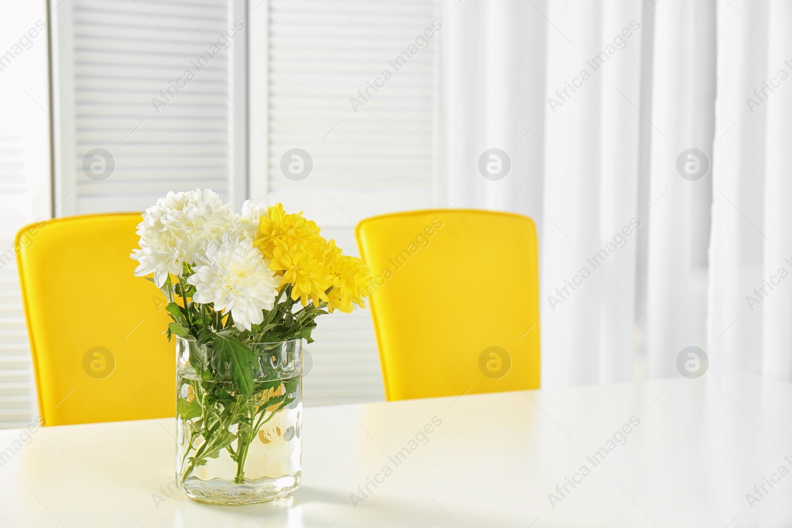 Photo of Vase with blooming flowers on table indoors