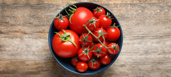 Image of Bowl with fresh tomatoes on wooden table, top view. Banner design 