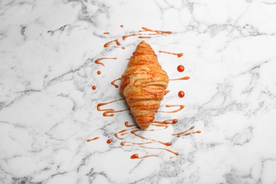 Fresh croissant and jam on white marble table, top view. French pastry