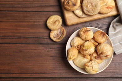 Photo of Tasty dried figs on wooden table, flat lay. Space for text