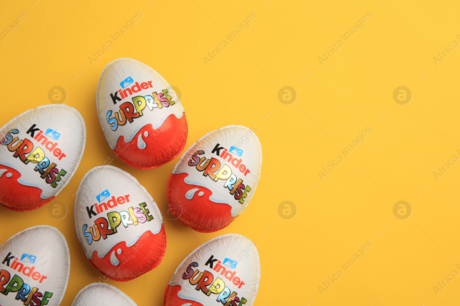 Photo of Sveti Vlas, Bulgaria - June 26, 2023: Kinder Surprise Eggs on orange background, flat lay. Space for text