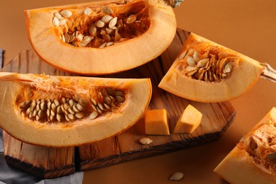 Cut fresh ripe pumpkin on orange background, closeup