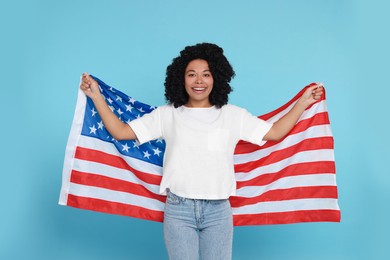 4th of July - Independence Day of USA. Happy woman with American flag on light blue background