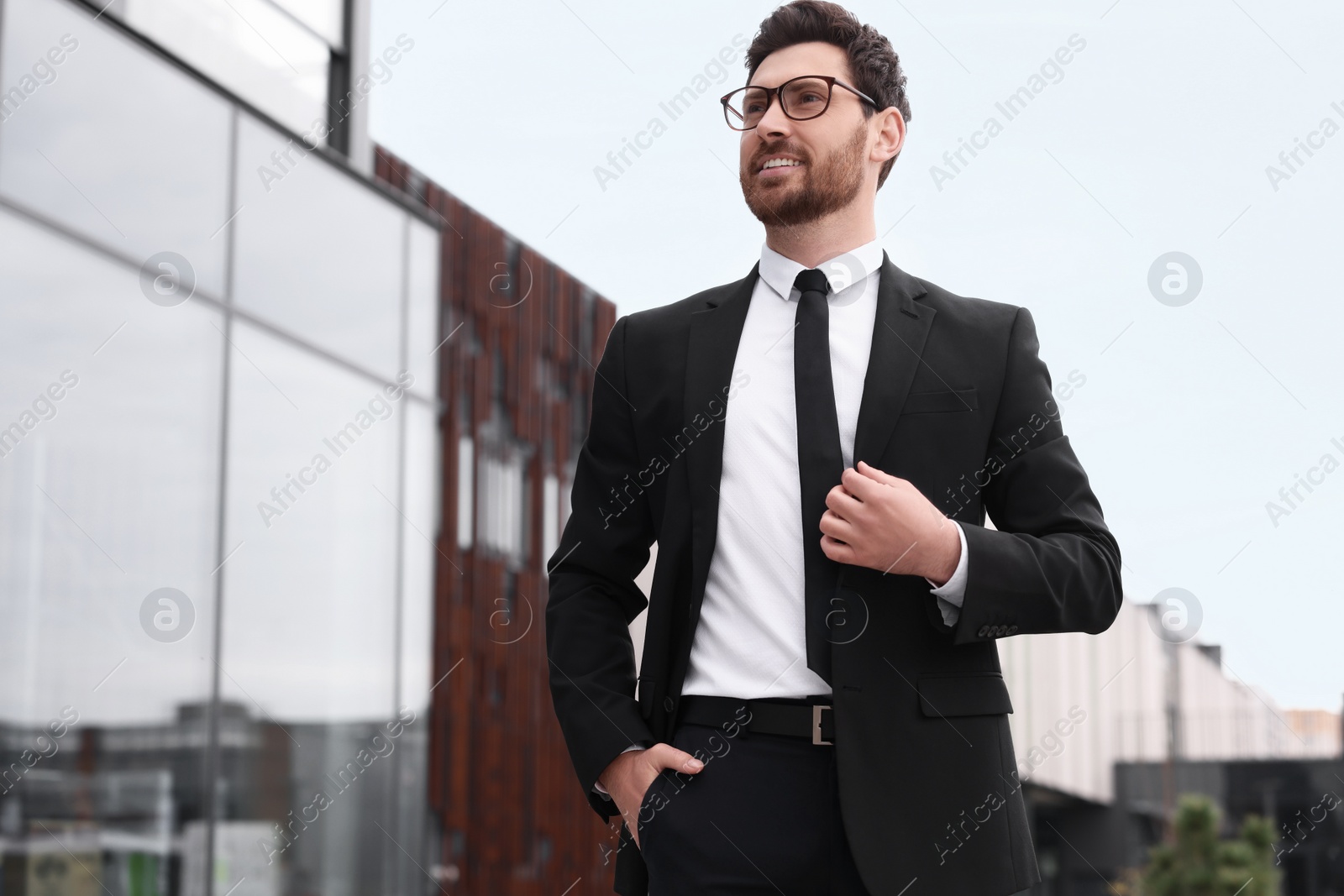 Photo of Handsome real estate agent outdoors. Space for text