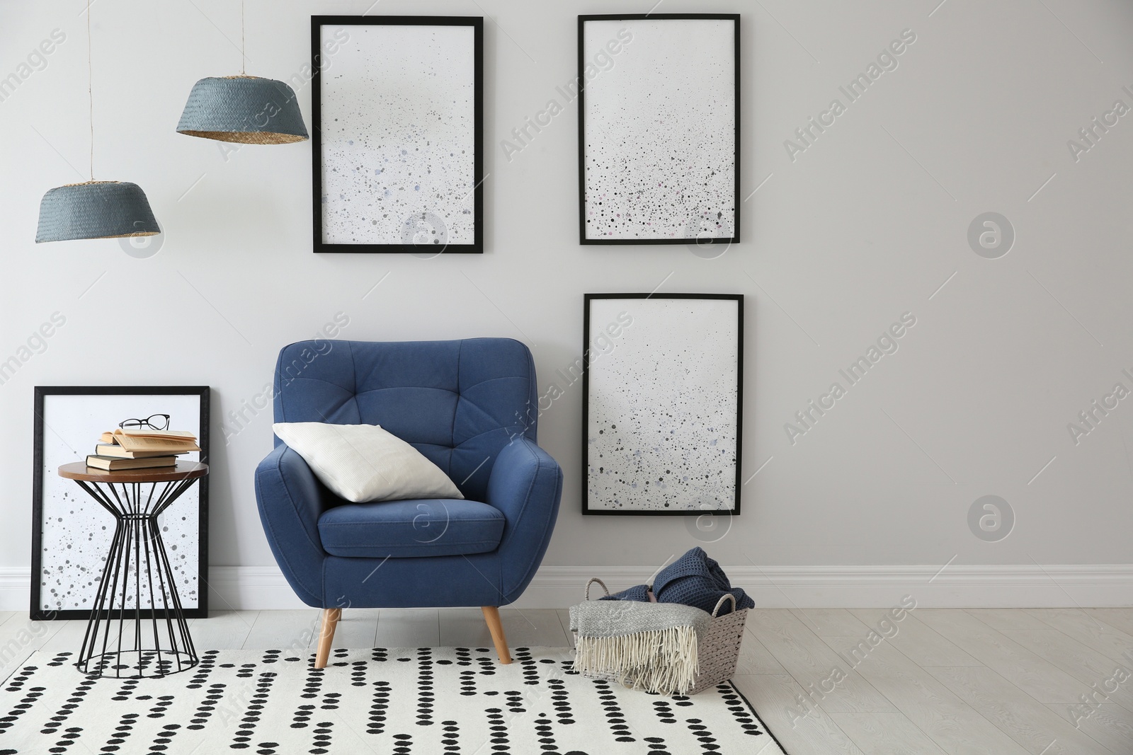 Photo of Beautiful artworks and comfortable armchair in stylish room. Interior design