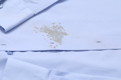 Closeup view of light blue shirt with stain
