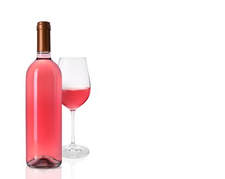 Bottle and glass of delicious rose wine on white background