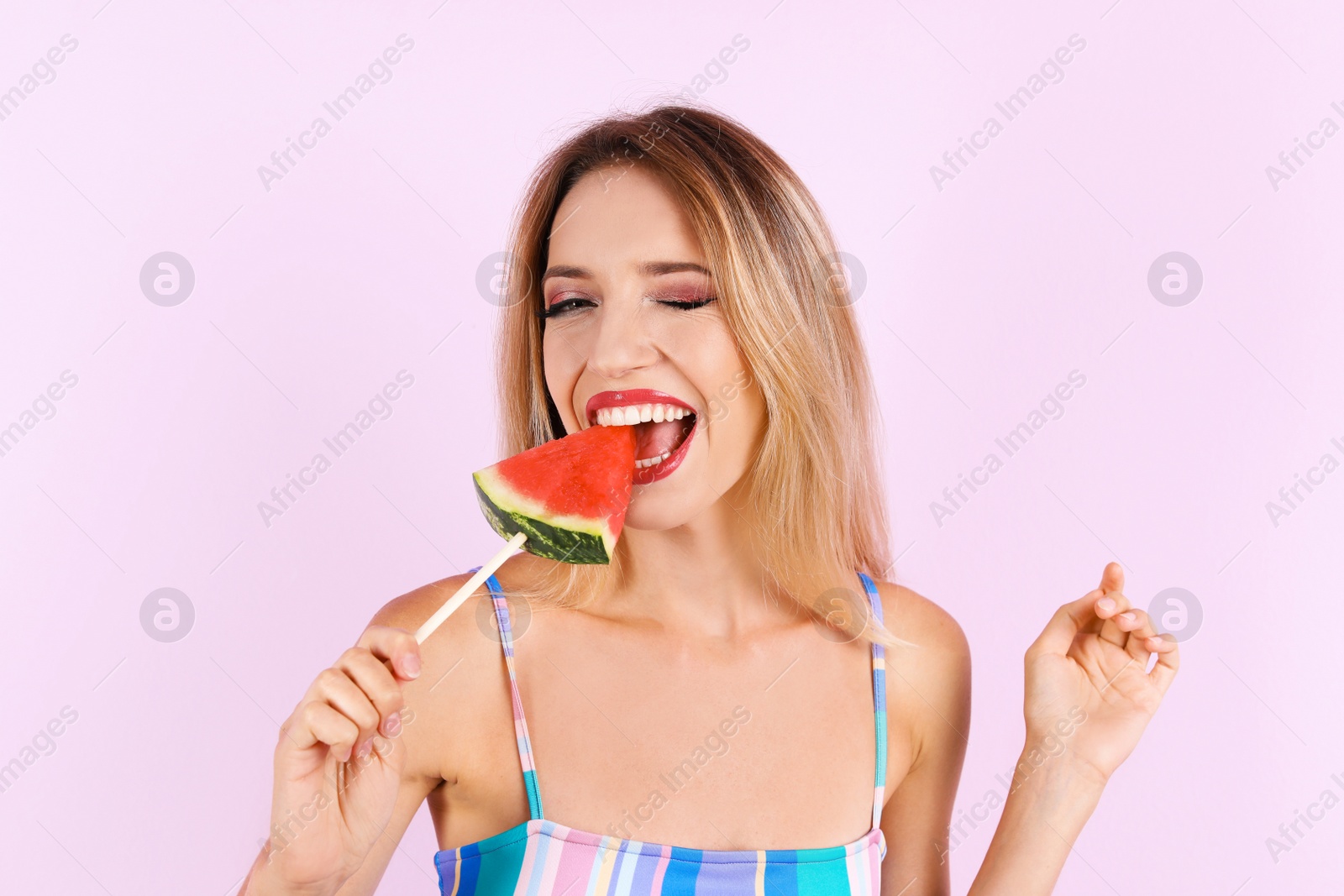 Photo of Pretty young woman with juicy watermelon on color background