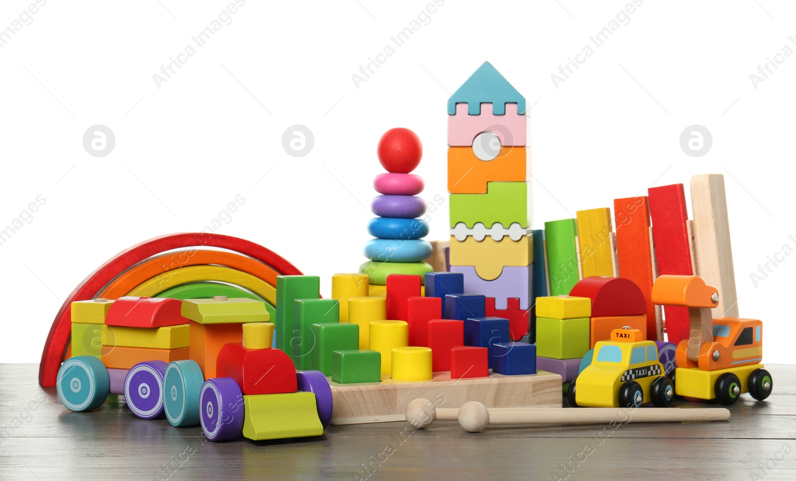 Photo of Different children's toys on wooden table against white background