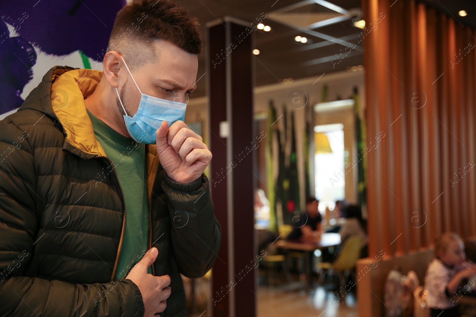 Photo of Man with disposable mask in cafe. Virus protection