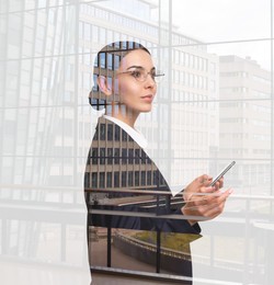 Double exposure of businesswoman with phone and cityscape
