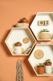 Photo of Shelves with decorative elements on color wall. Interior design