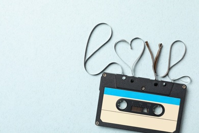 Photo of Top view of music cassette and word Love made with tape on turquoise background, space for text. Romantic songs