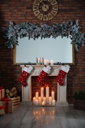 Beautiful fireplace with garland and Santa socks in Christmas room interior