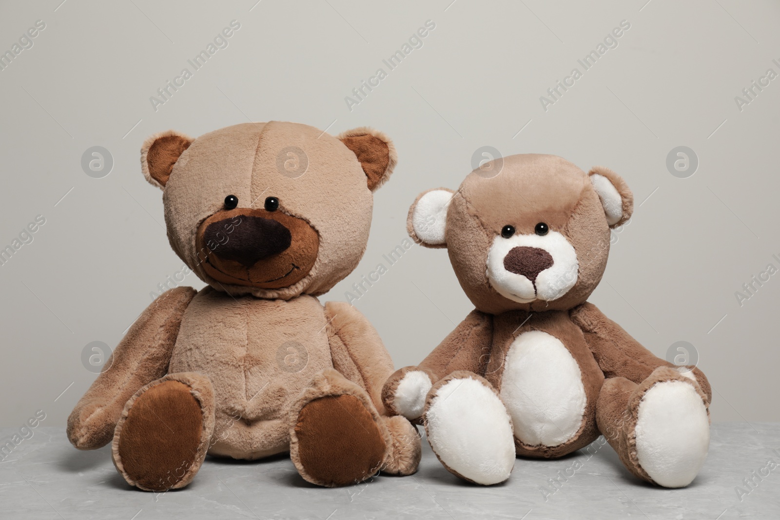 Photo of Cute teddy bears on light grey marble table