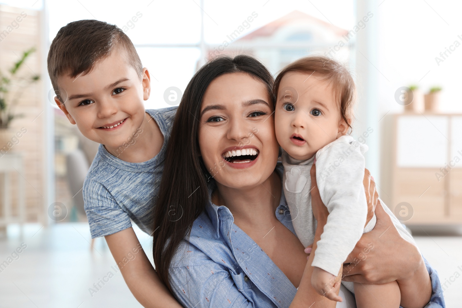 Photo of Happy mother with her cute children at home. Family time