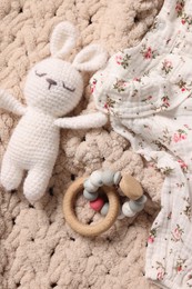 Baby accessories. Toys and cloth on knitted fabric, flat lay