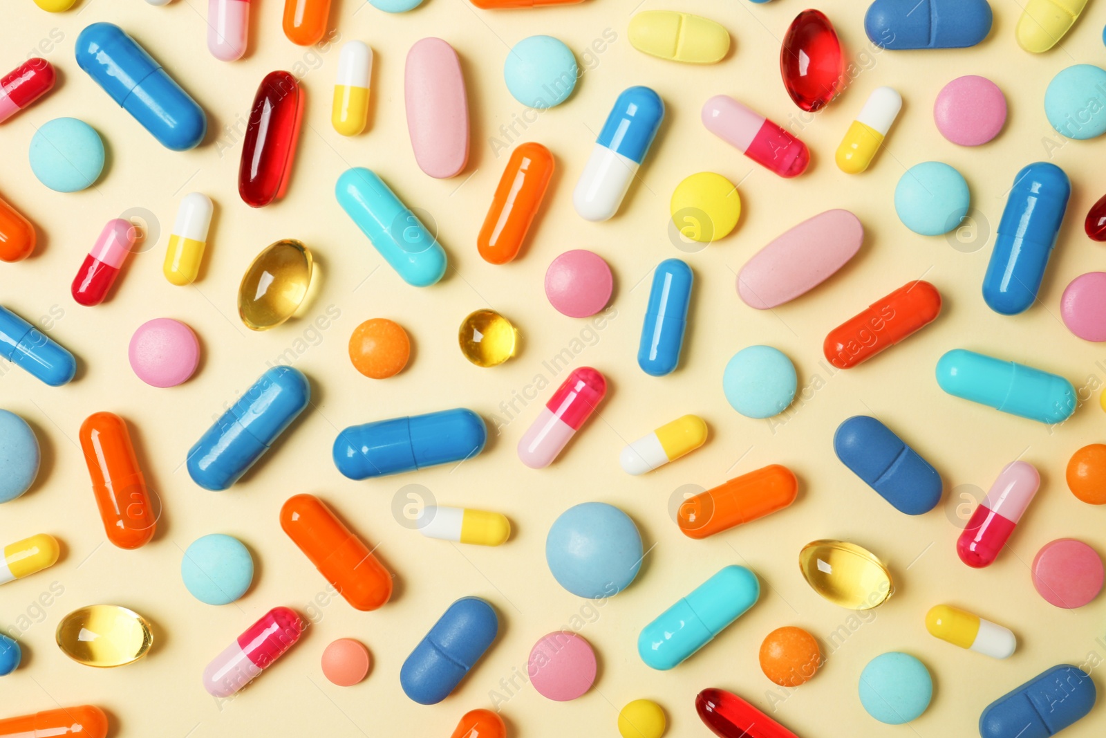 Photo of Many different pills on color background, top view