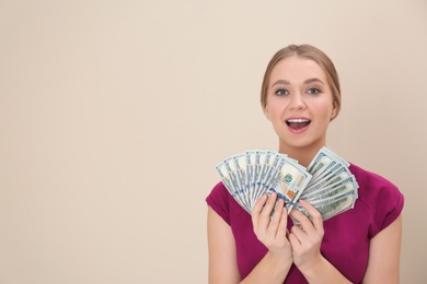 Portrait of happy young woman with money on color background. Space for text